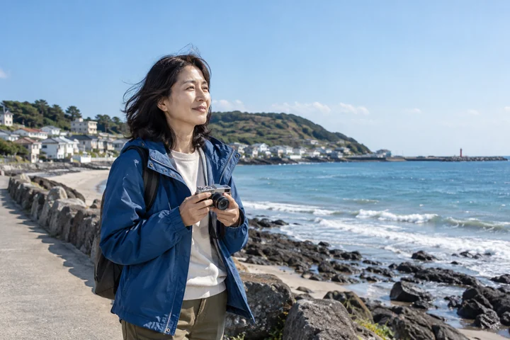 해변에서 사진을 찍는 여성 — 여성 실사 바닷가 여행 견본